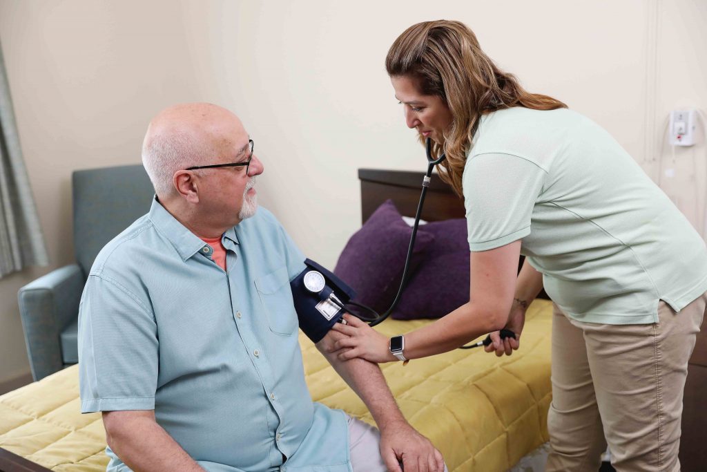 Nurse takes blood pressure of rehabilitation resident.
