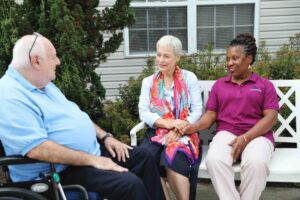 Crane's Mill Assisted Living resident with wife and caregiver on the patio.