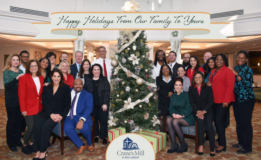Portrait of Crane's Mill team in front of holiday decorations and Christmas Tree